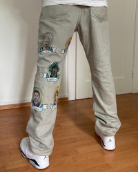 a man wearing a pair of jeans with a lot of pictures on them