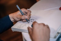 a man is drawing a picture on a piece of paper