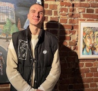 a man standing in front of a wall of art