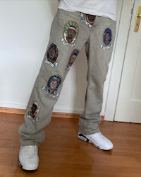 a man wearing a pair of jeans with patches on them